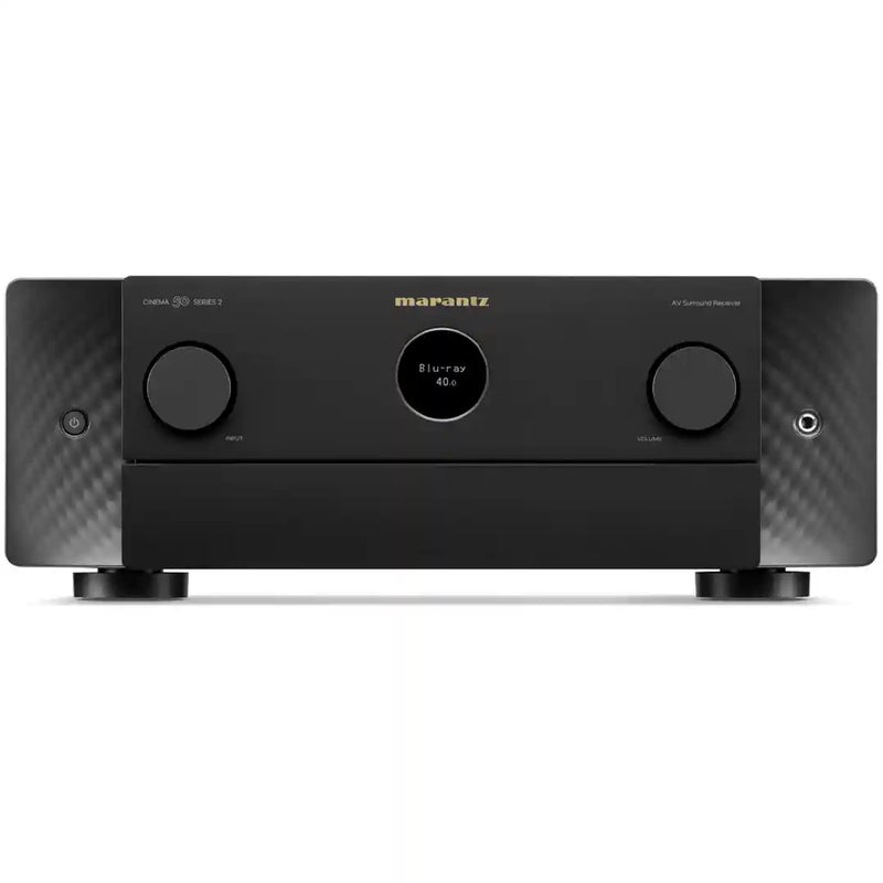 A Marantz AV Receiver 4K Ultra HD in matte black, featuring two large front control knobs, a central round display, and a carbon fiber pattern on the side panels, set against a plain white background.